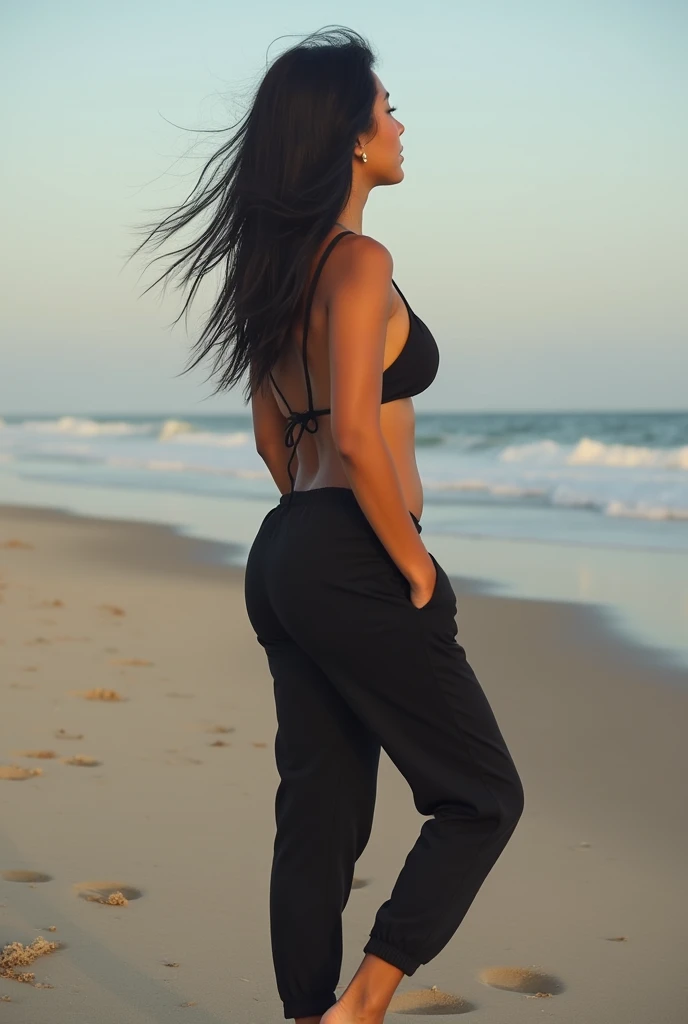 black hair, black sweatpants, Barefoot woman takes off her bikini and lies naked on the beach