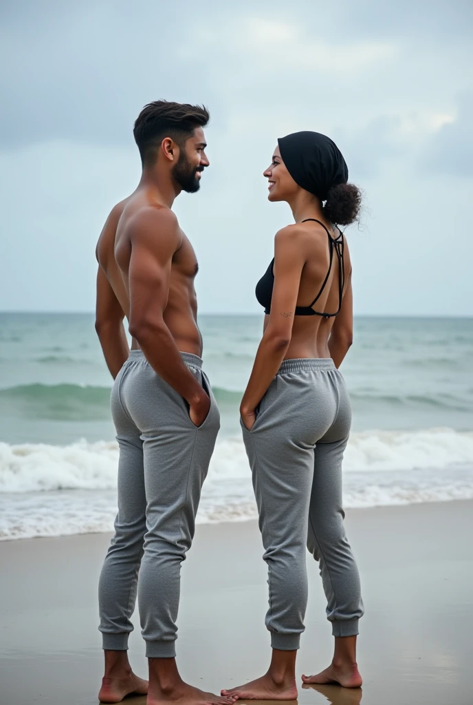 with black headscarf, grey sweatpants, in bra, Barefoot woman talking to her boyfriend on the beach