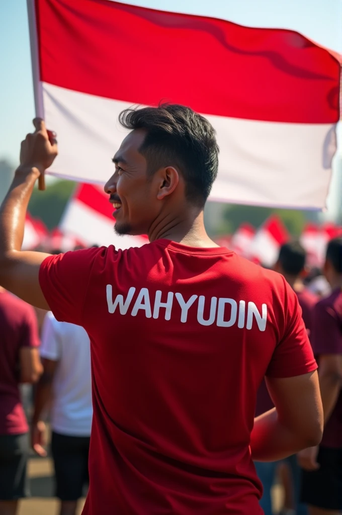 Adult man holding Indonesian flag wearing red t-shirt with name on t-shirt WAHYUDIN facing backwards