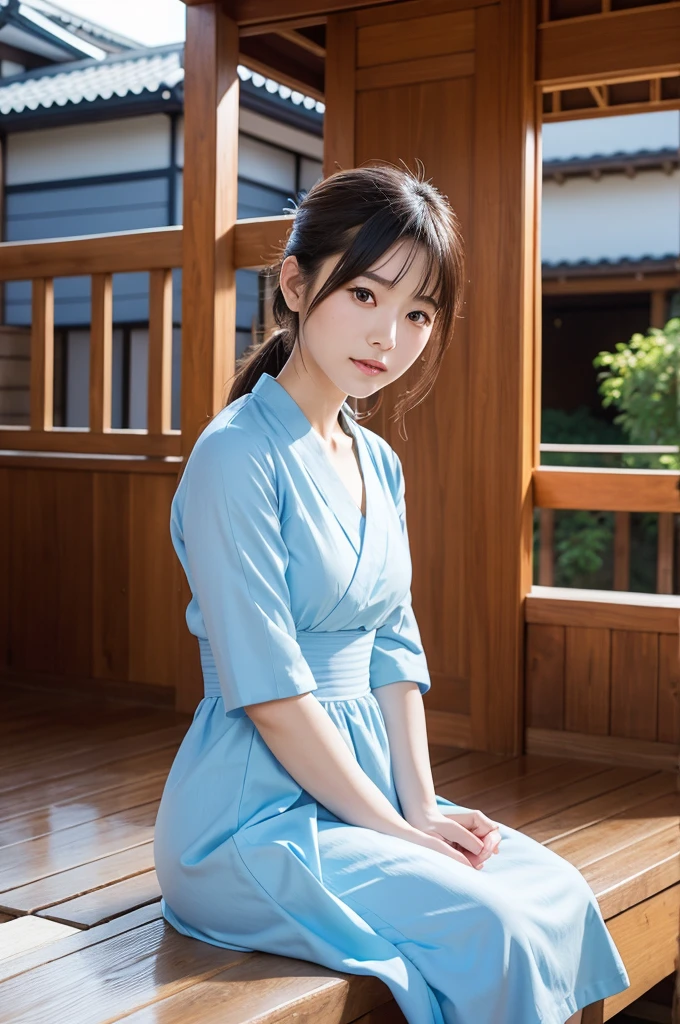 Beautiful Asian European woman with cute face wearing light blue dress is posing sitting on the terrace of a traditional Japanese wooden house