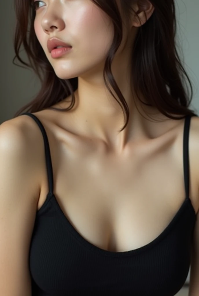 An Japanese woman in a black tank top, with the close-up focusing on the contours of her shoulders and breasts, showing the softness and delicate glow of her skin.