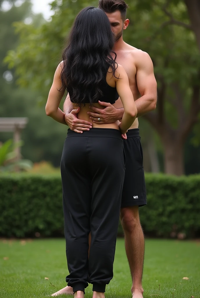 Black hair in the garden, black sweatpants , Barefoot woman. Man touching woman&#39;s butt with the front of his panties from behind