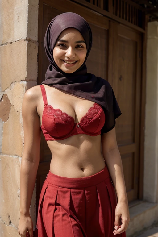 A muslim woman wearing a red bra and long skirt is smiling 