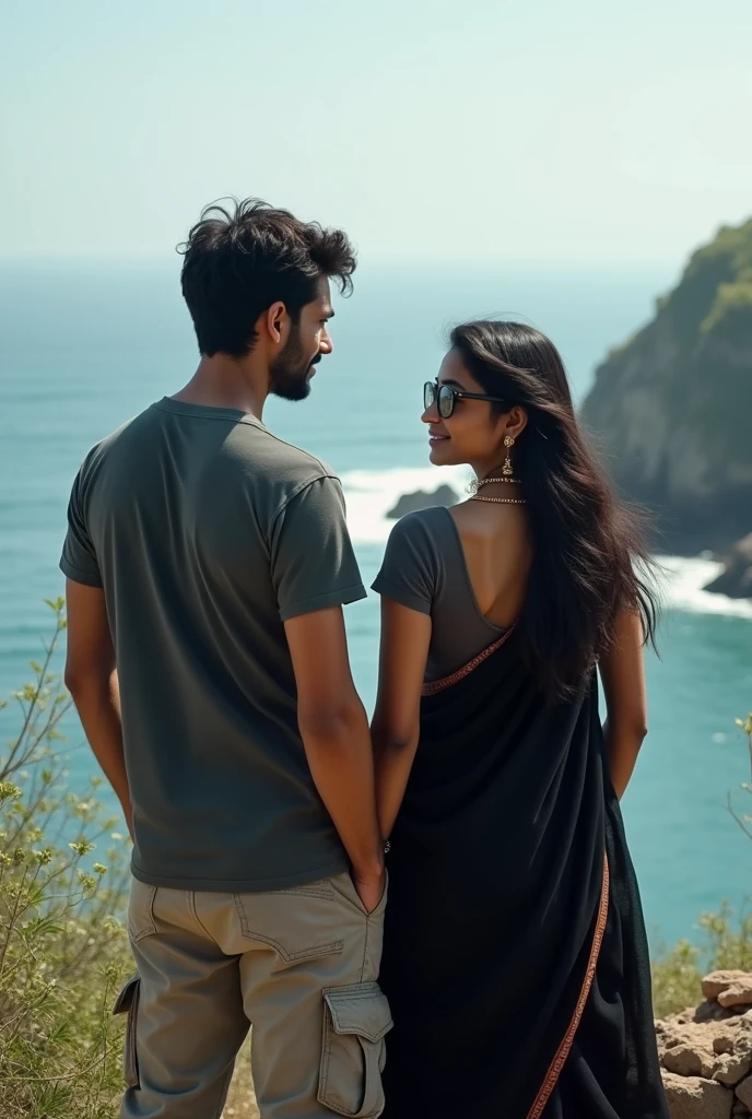 A 25 year boy wearing cargo and Indian girl in black saree wearing round spectacles. They are standing on heal surrounded by the ocean. Takeing photo from back side