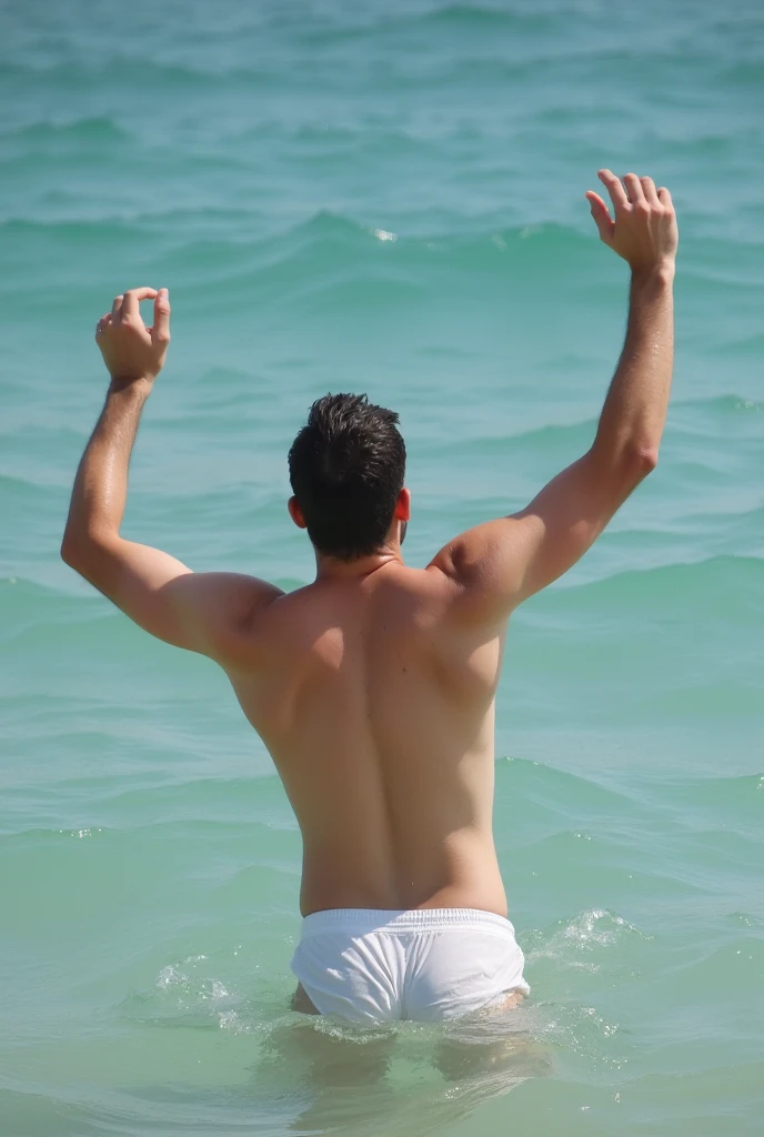 A man takes off his shirt, is playing in the water, wearing underwear, white skin, raising both thin arms, white underwear, facing away.