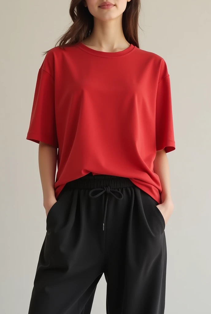 A red, loose-fitting, crew-neck women's t-shirt with a blank spot opposite the belly button and loose black pants.