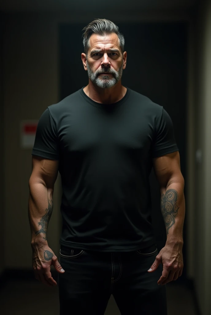 male, 5'6", Dark brown short hair with gray 2 level, Longer hair on top 4, Muscular arms, Tattoo on left upper arm, Short-sleeved black T-shirt, Medium build, Black jeans, Short and tight beard slightly graying, In a very dark room, Average looking,