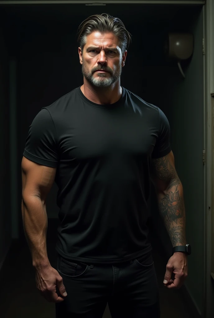 male, 5'6", Dark brown short hair with gray 2 level, Longer hair on top 4, Muscular arms, Tattoo on left upper arm, Short-sleeved black T-shirt, Medium build, Black jeans, Short and tight beard slightly graying, In a very dark room, Average looking,