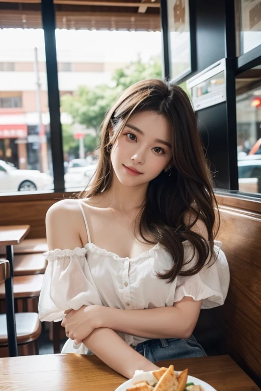 The image is a portrait of a young woman sitting on a bench in a restaurant. She is wearing a white blouse with ruffled sleeves and denim shorts. Her long brown hair is styled in loose waves and falls over her shoulders. She has a serious expression on her face and is looking off to the side with a slight smile. The background is blurred, but it appears to be a busy restaurant with other people sitting in the background. The overall mood of the image is relaxed and casual.