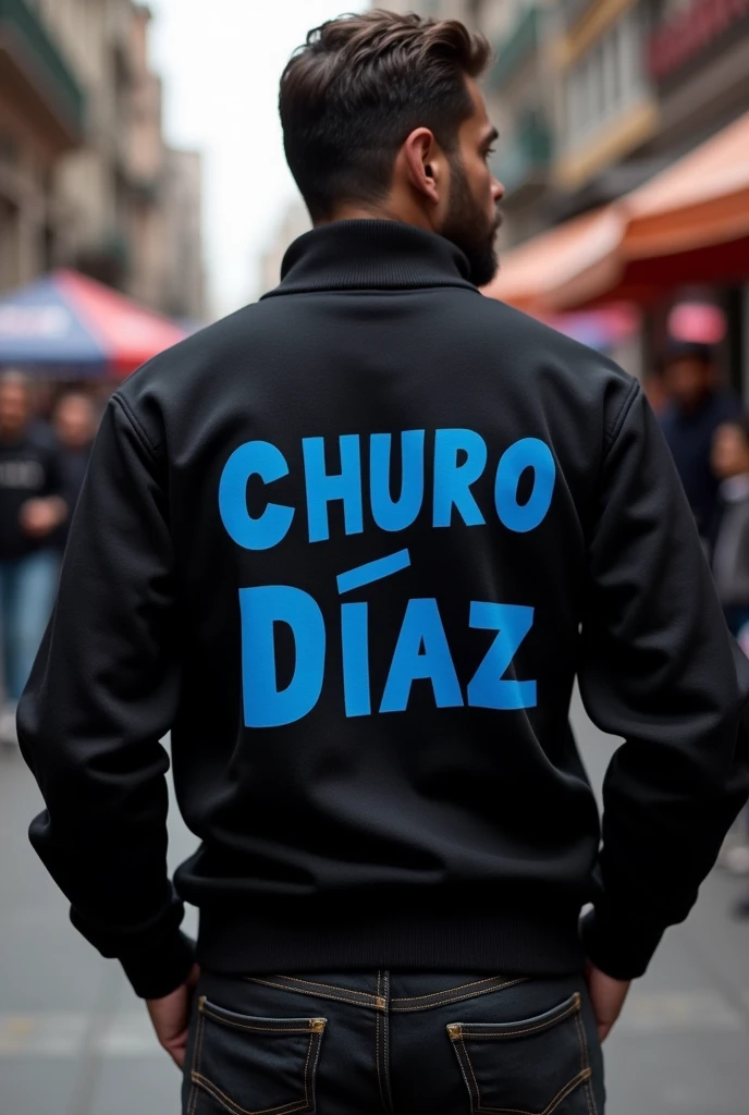 Black sweater that says Churo Díaz el Fuete in blue letters