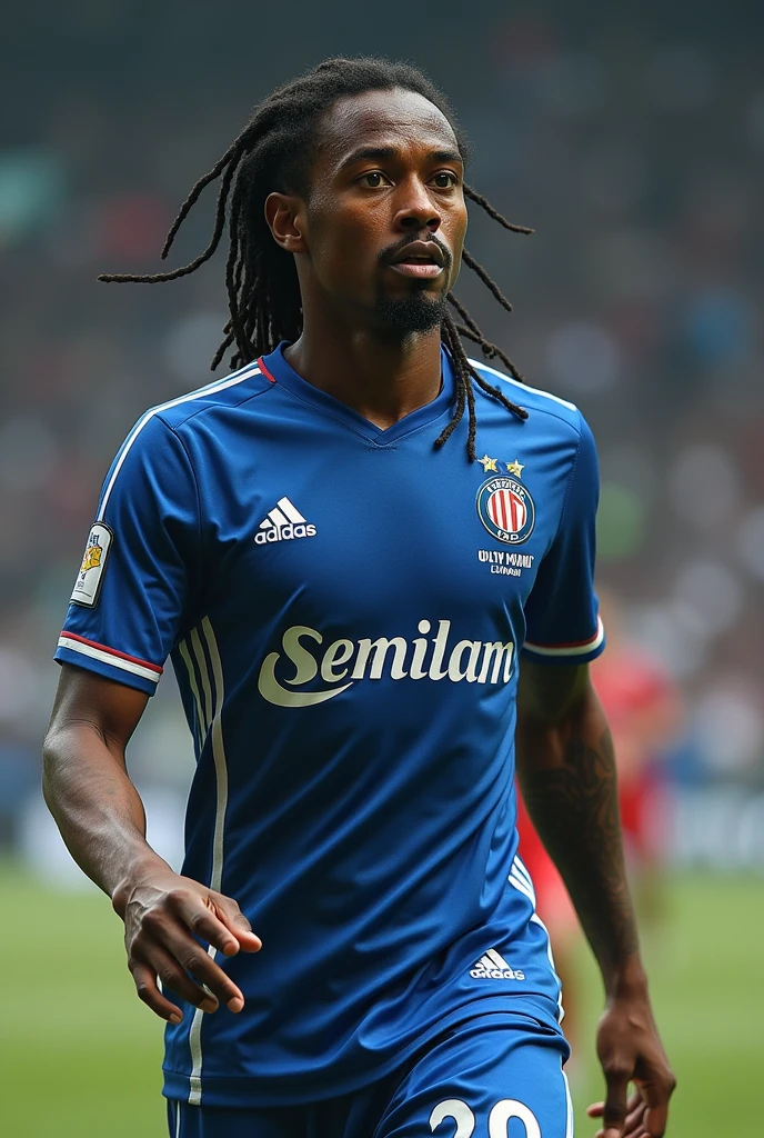 Joueur de football de l'olympique lyonnais avec peau blanche, cheveux noir avec un p’tit bouc, et des longue dreadlocks attaché