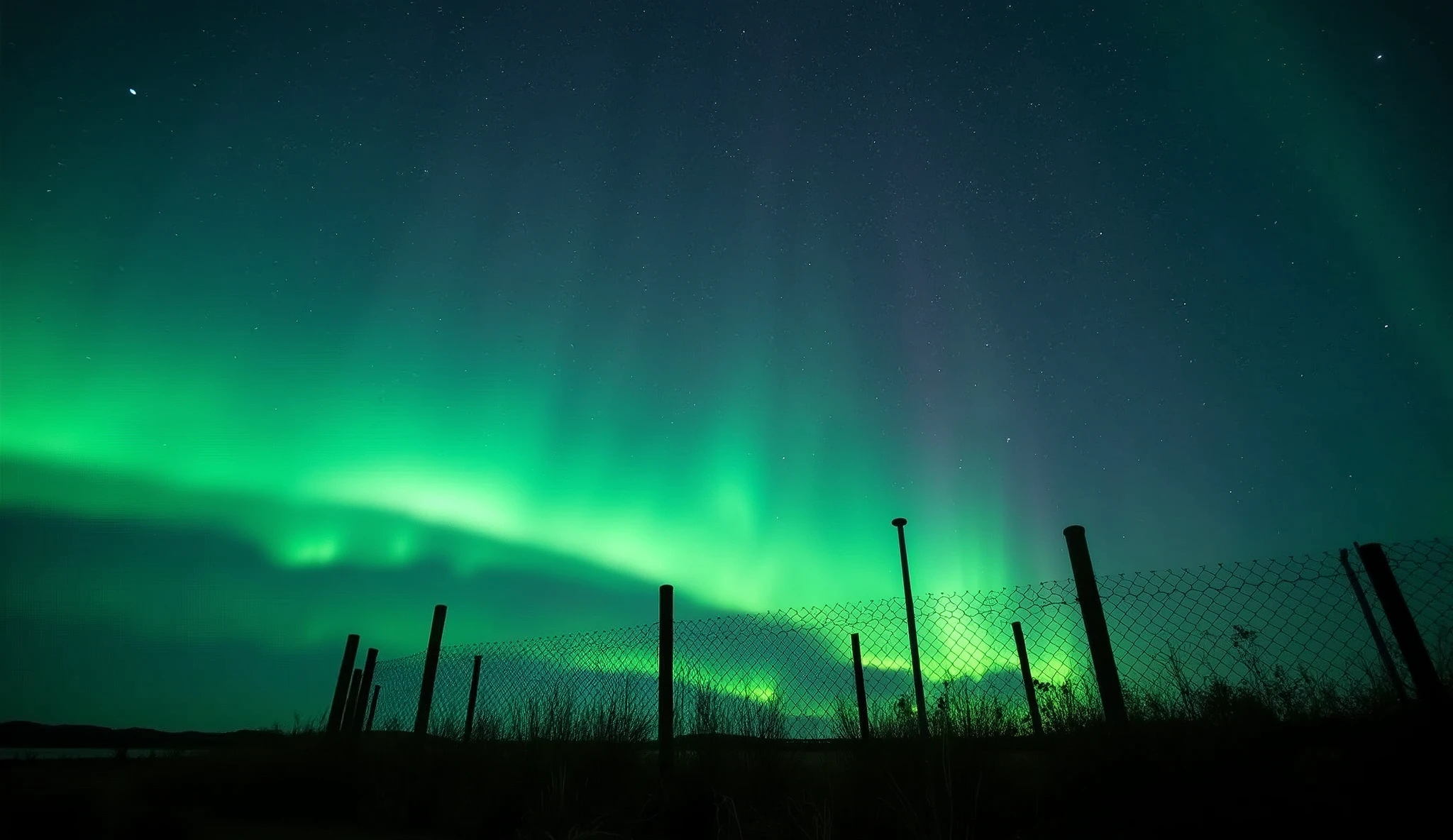 Starry sky, fence, aurora green light, photography, in the style of Nikon