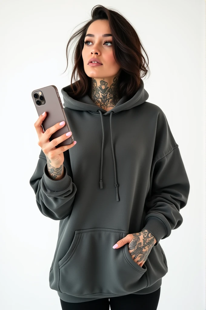 A lady with tattoos wearing a hoodie handing iPhone, white background