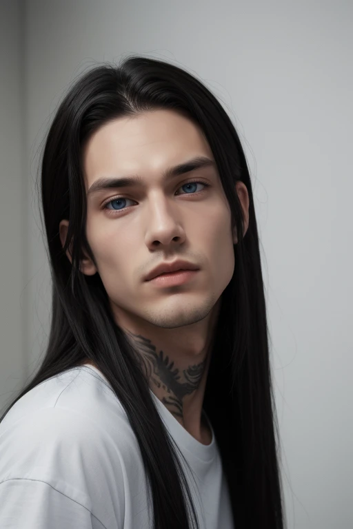 A young man with long black hair and blue eyes. His face is serious, he has a strong jawline. He is tall and thin. He wears a white teeshirt and is in a plain grey room. He has tattoos.