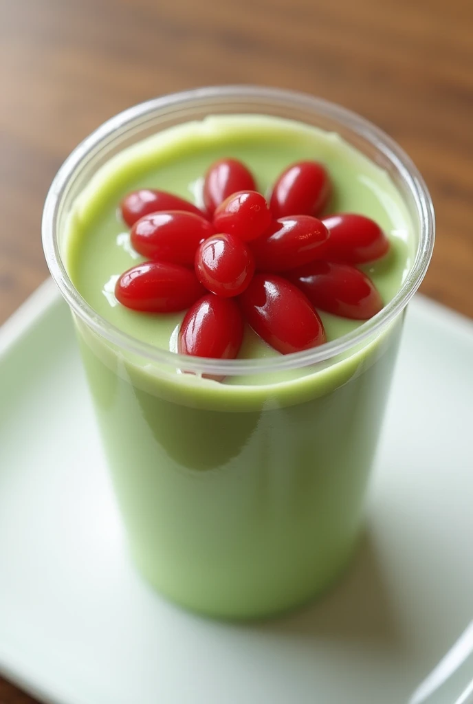 matcha Pudding with red beans on top in a clear plastic small cup  
