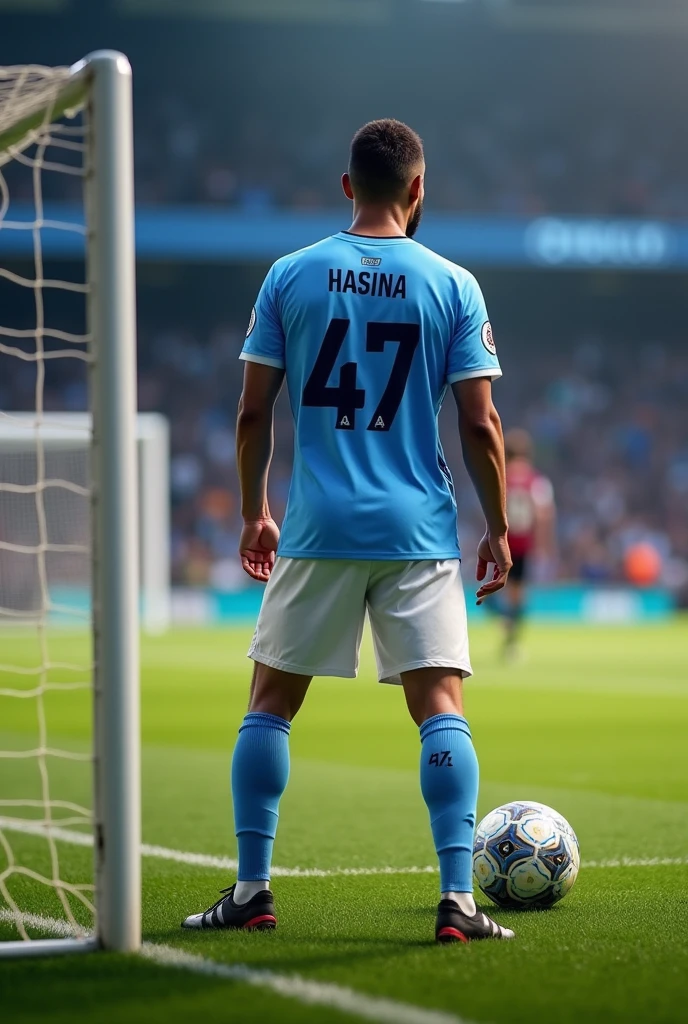Un jeune homme de porte le maillot de Manchester City anommé "HASINA"au dos , numero 47 ,prêt pour frapper un penalty