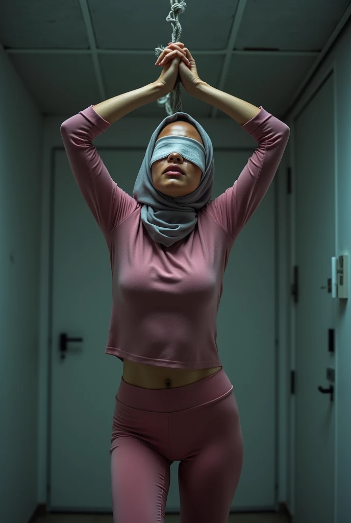 (Photography)(dynamic) Show a Malay female, hanging  in the middle of room. Wearing hijab, pink skintight inner and leggings. Blindfold. Hands tied together upwards. Crying.