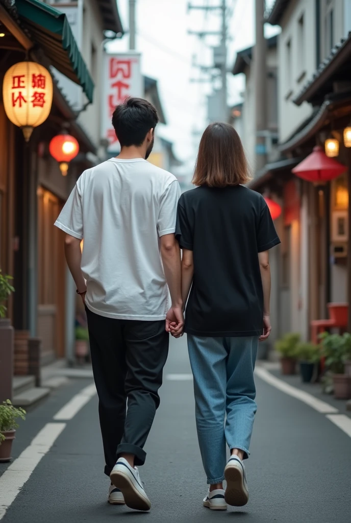 A photo of a young couple wearing black and white t-shirts and facing away from the camera., Japan
