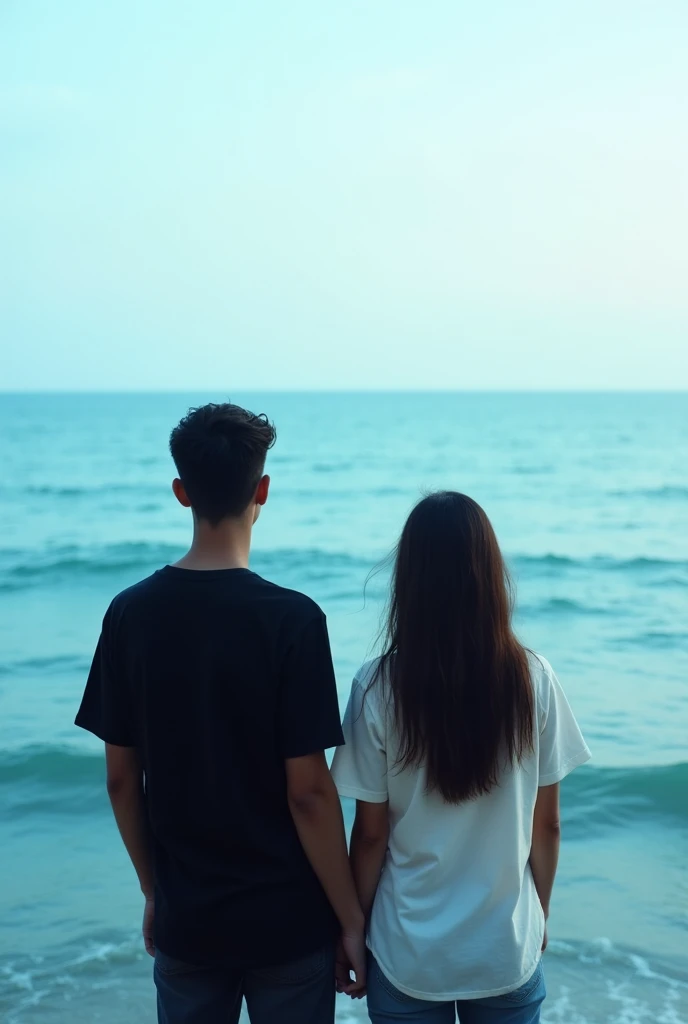 A photo of a young couple wearing black and white t-shirts and facing away from the camera., Ocean