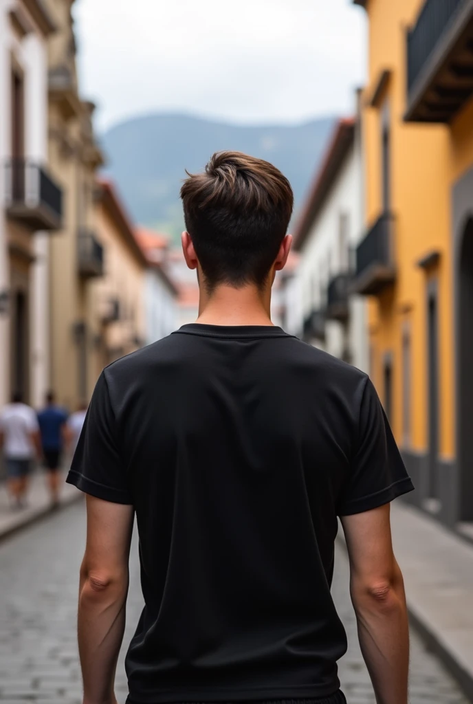 Young man with black t-shirt from behind in the historic center of Cuenca, Ecuador