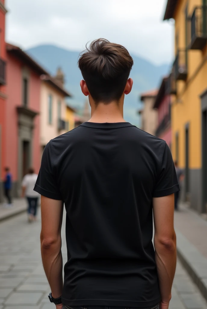 Young man with black t-shirt from behind in the historic center of Cuenca, Ecuador