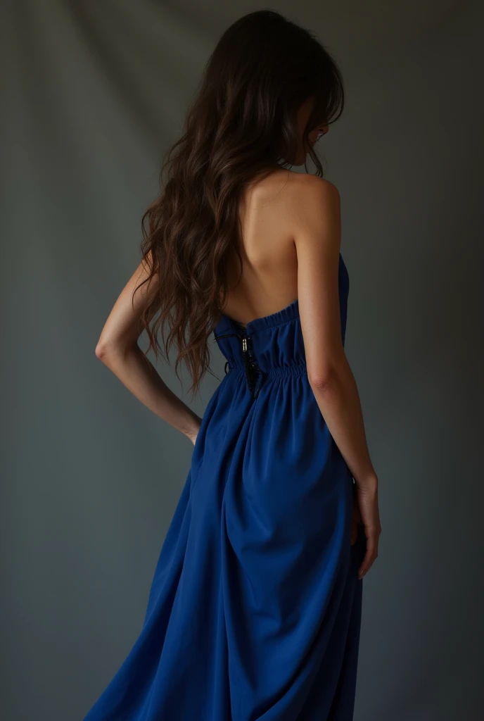 A thin brunette woman with one hand on her waist, wearing a royal blue dress, from the back so as not to show the face and with long brown hair down to the waist and that the photo looks real and with slightly long nails
Without showing the face, I would like her to have her back turned, with a bit longer hair and be a little bit more tanned, please. I would also like the dress to be less revealing.