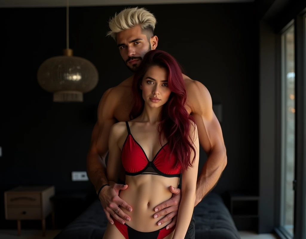 Two people, young toned woman, short height, vibrant maroon long wavy side-parted hair wearing a red/black bra and red/black panties. Behind her, an extremely tall 33-year-old attractive Arabic male model, short platinum blond textured short cut swept-back, long black stubble, brown skin, lean body, hands on her hips. Inside a modern black chic bedroom, low lighting.