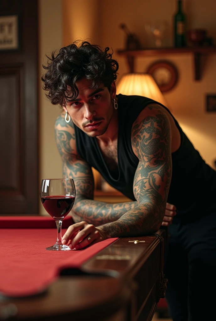 Handsome dark-haired tattooed man,with curly hair, drinking wine while playing pool at home