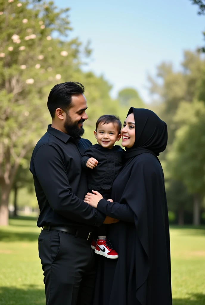 Family photo consists of father mother and a son aged s, mother wearing black hijab father and son wearing black shirt long pants.