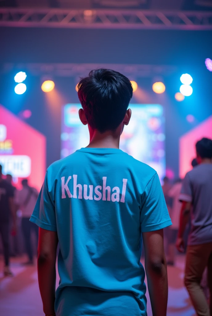 "Create an image of a 19-year-old boy with a 50kg weight, wearing a t-shirt that has 'IITG' written on it along with the name 'Khushal.' The boy is seen from behind, with the t-shirt covering his back and part of his head. The setting is a vibrant function called 'Techniche,' capturing the energy and excitement of the event. and he is on backstage the tag of functiin should be there in image and boys back should compleyely visible