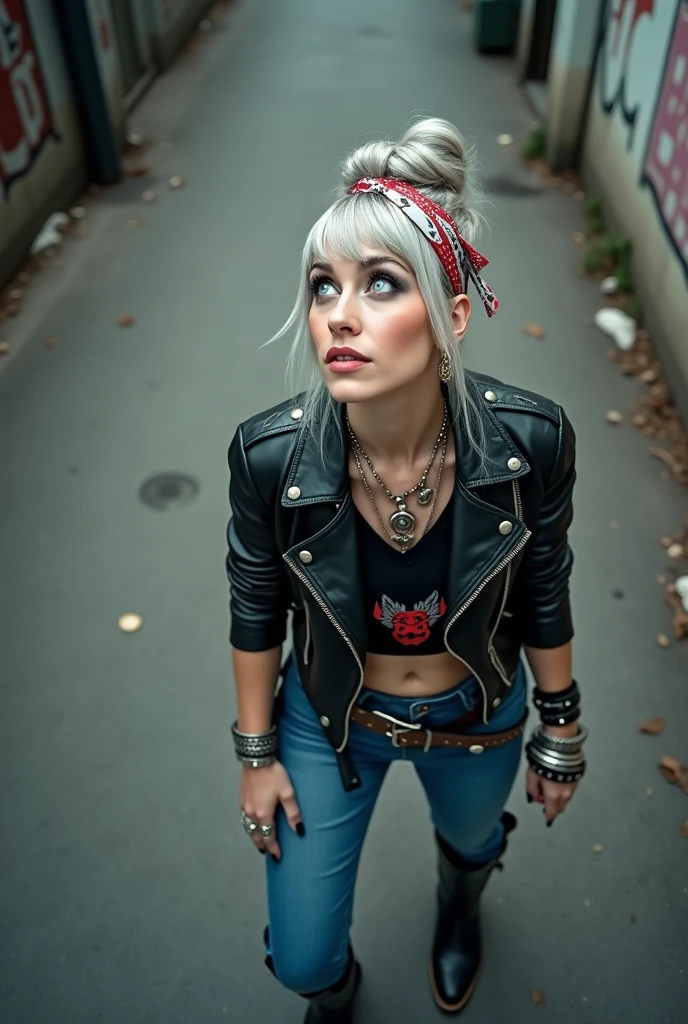 russian milf woman, grey hair (huge ponytail) and bandana as headband, with very light blue eyes, extremely pale. Wearing cropped black moto jacket with lots of zippers and pins Pins and badges on jacket. Cropped t-shirt with guns and roses logo, dark skinny blue jeans and pointy black Chelsea boots with cuban heels  . Lots of metallic bracelets and collars. Tacky wide studded leather belt with oversized skull and bones buckle. Long earrings. Kneeling like in a payer, a little bent, looking up, eyes and mouth wide open in amazement. Hands on her knees. Listening in amazement to somebody speaking to her, toned six pack abdominals, thin legs and thin arms. Very tattoed. Studded black leather boho bag with chains  next to her. A lot of people around looking at her