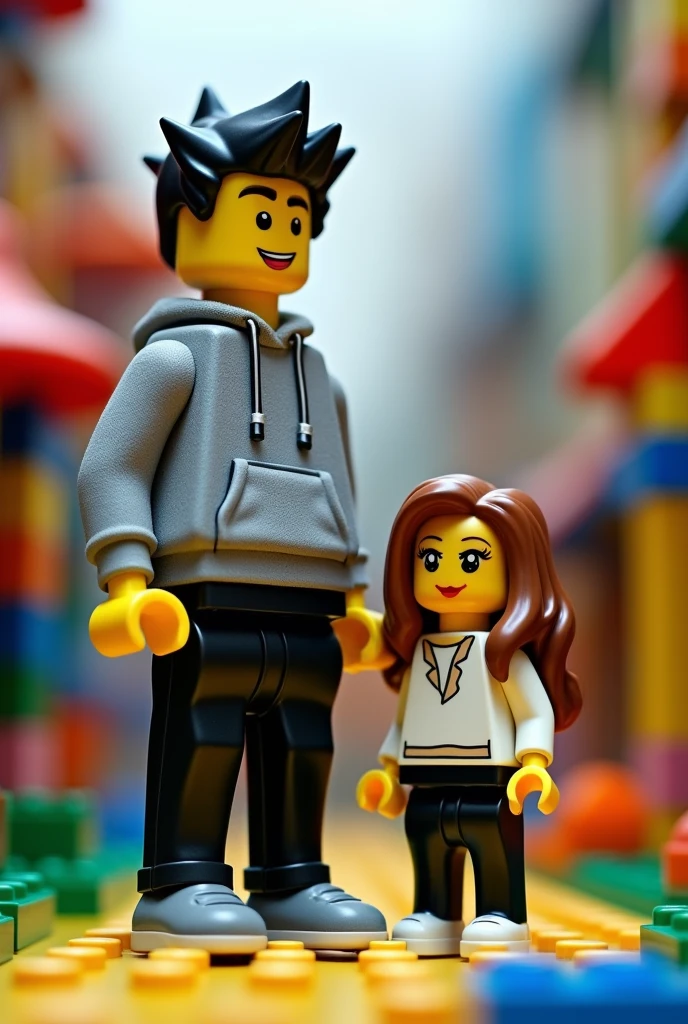 Lego characters a woman and a man, the tallest man and the shortest woman, the man who is black haired, with a gray sweatshirt and black pants and the woman with black pants and white top and with brown hair