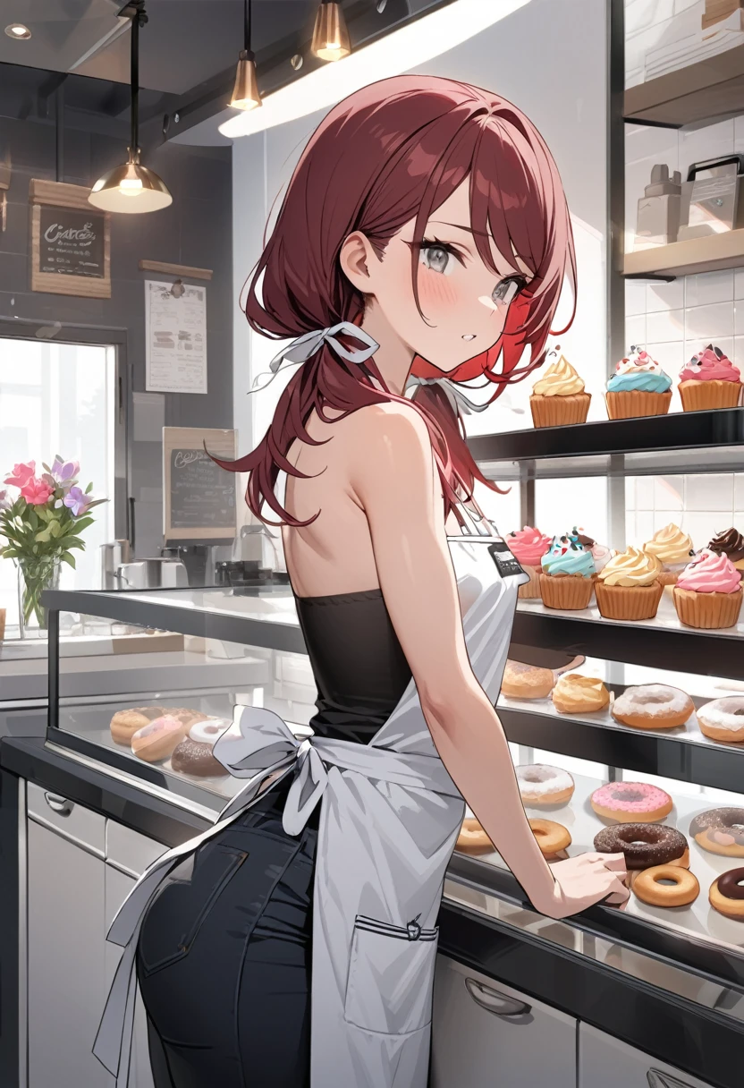 Masterpiece, highres, high Quality, detailed face, over-the-shoulder shot, solo, working behind counter, Gray eyes, dark red hair, swept bangs, low twin tails, white ribbons, gray strapless shirt with white trim, apron, nametag, black jeans, small breasts, toned arms, frosting cupcakes and donuts behind glass, kitchen, cafe, potted flowers,