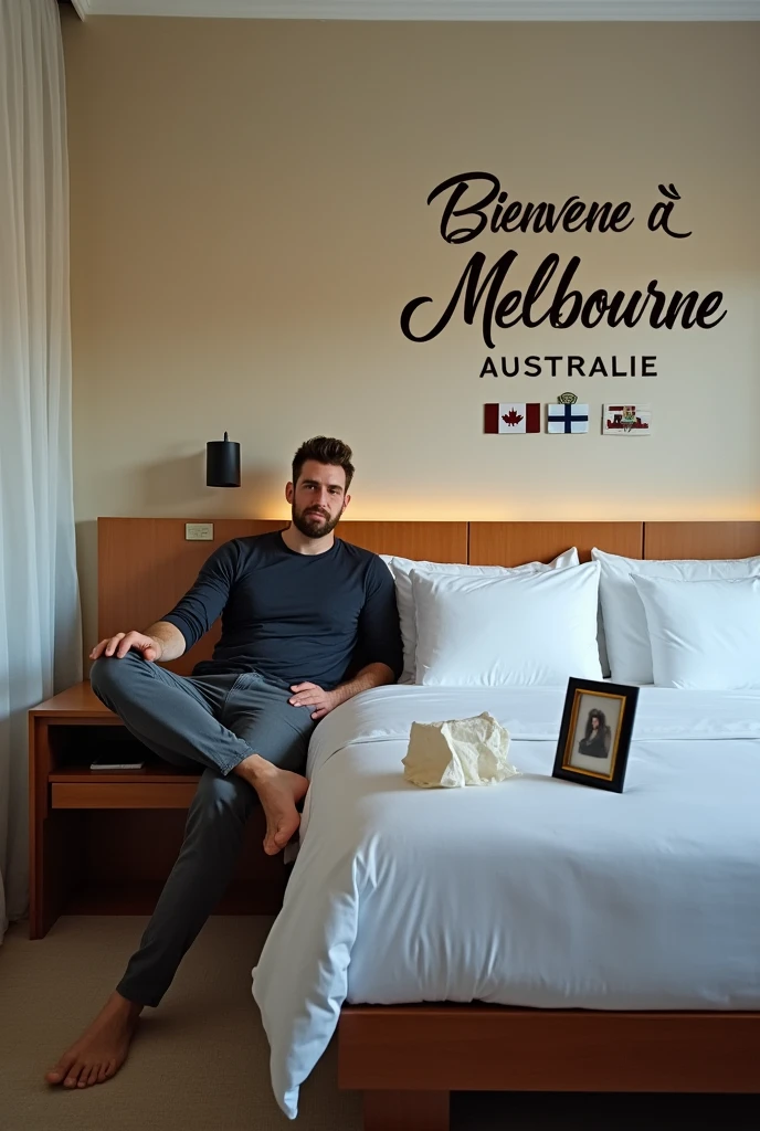 Homme caucasien grand de taille, charmant, un peu costaud, habillé en pantalon et tee-shirt manche longue, assis ou adossé sur une table dans une grande chambre d'hôtel, sur la table qu'il y ait également un papier mouchoir déjà utilisé sur la table et sur le lit de l'hôtel qu'il soit déposer un cadre photo grand ou moyen qu'il est possible de faire arrêter sur le lit et faire face à la caméra et sur le mur du chevet du lit un tableau sur lequel il est écrit en français : Bienvenue à Melbourne AUSTRALIE et autour de la phrase qu'il y ait les emblèmes du Canada Québec ou le drapeau du Canada Québec
