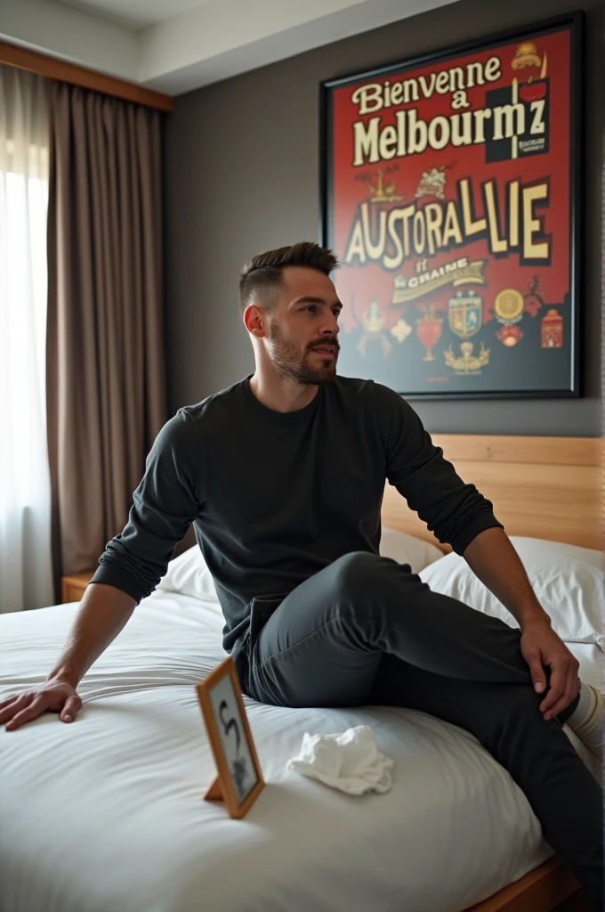 Homme caucasien grand de taille, charmant, un peu costaud, habillé en pantalon et tee-shirt manche longue, assis ou adossé sur une table dans une grande chambre d'hôtel, sur la table qu'il y ait également un papier mouchoir déjà utilisé sur la table et sur le lit de l'hôtel qu'il soit déposer un cadre photo grand ou moyen qu'il est possible de faire arrêter sur le lit et faire face à la caméra et sur le mur du chevet du lit un tableau sur lequel il est écrit en français : Bienvenue à Melbourne AUSTRALIE et autour de la phrase qu'il y ait les emblèmes du CANADA QUÉBEC ou le drapeau du CANADA QUÉBEC