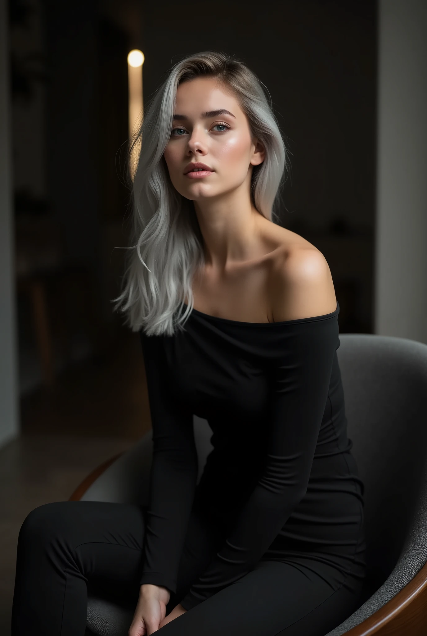 Girl sitting elegantly on a modern chair, against the background of a dark room, black off shoulder top, light gray hair