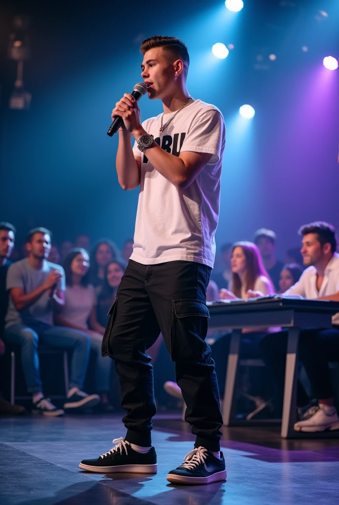 **Image Description**:
A 17-year-old white rapper is performing on stage during an audition, with his look clearly visible on camera. He is wearing black cargo jeans, OG sneakers, and a white hip-hop T-shirt with "YABU" written on it. His haircut is a 0 on the sides with a slight slope. He holds a microphone in his hand and is deeply engaged in his performance. Three judges, seated at a table in front of the stage, watch him intently. The audience is visible in the background, observing from the side. The stage is brightly lit, emphasizing the rapper's dynamic and energetic presence.