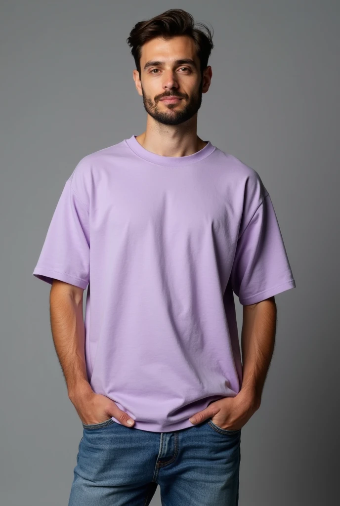 Handsome man, standing straight facing in front,wearing  levendar colour oversized t-shirt, denim pants, against greyish background, cotton texture of t-shirt, oversized tshirt,round neck, half sleeves. Cotton texture of t-shirt should be visible little bit.realistic photo. Hands should be out of pocket.