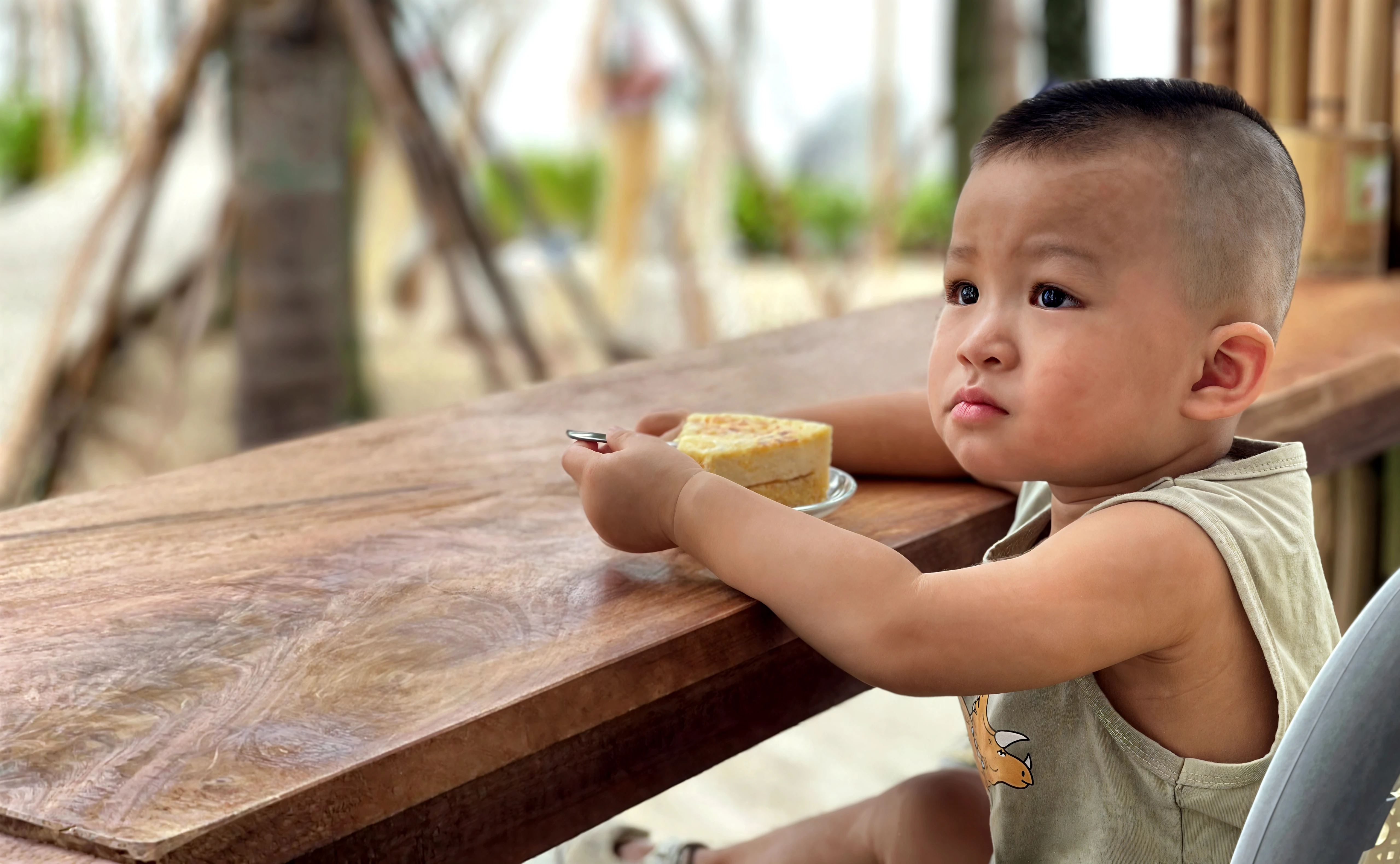 there is a young boy sitting on the grass eating a piece of food, portrait shot, young commoner, photo taken with nikon d750, photo taken with nikon d 7 5 0, mid shot portrait, closeup portrait shot, with yellow cloths, cute boy, traditional photography, young girl playing flute, marvelous expression, full body photogenic shot, serene expression
