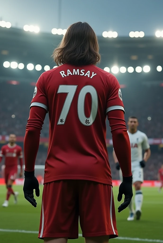 A Liverpool player named Ramsay who wears number 70 and also has long sleeves and black gloves and wavy hair about to take a penalty seen from behind