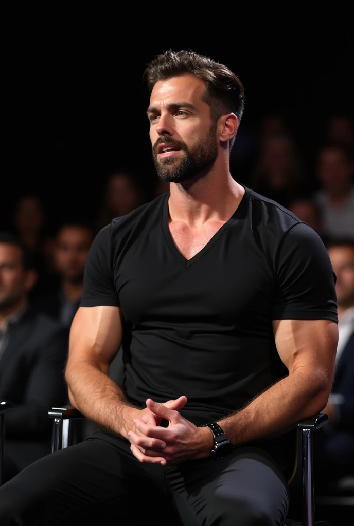 a very handsome muscular Italian man at the conference.
He has a hard jawline, dimpled chin, wide shoulder s.
He is wearing a very silky black fit deep v-neck tshirt and black trousers.
He is sitting comfortably on a chair. He is captured mid speech in front.