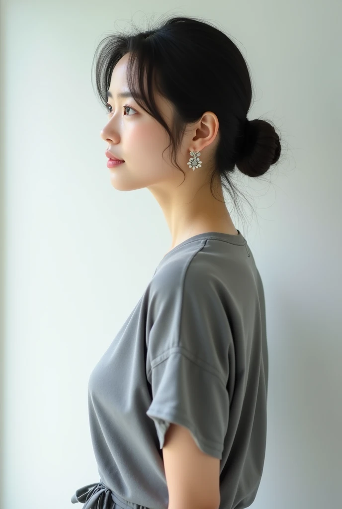 Highest quality、Photographed in natural light、Highly realistic photos、Detailed beautiful face、Japanese women、profile、One person、30-year-old female、Summer clothes、カジュアルなグレーのSummer clothes、Bun Hair、Don't look at the camera、indoor、In front of a white wall、Big Breasts,Simple earrings