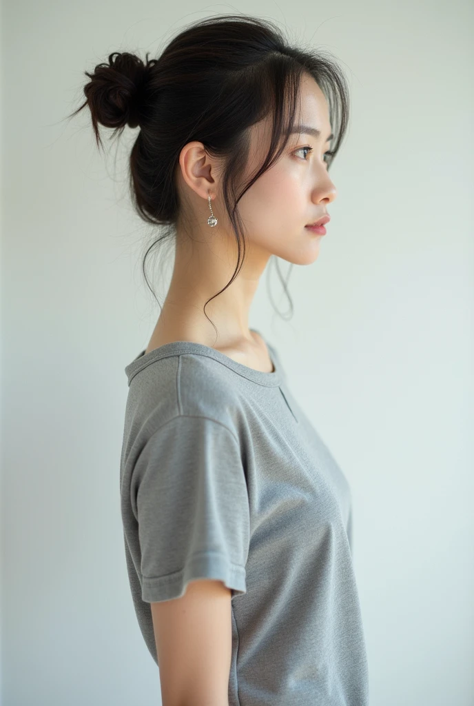 Highest quality、Photographed in natural light、Highly realistic photos、Detailed beautiful face、Japanese women、profile、One person、30-year-old female、Summer clothes、カジュアルなグレーのSummer clothes、Bun Hair、Don't look at the camera、indoor、In front of a white wall、Big Breasts,Simple earrings
