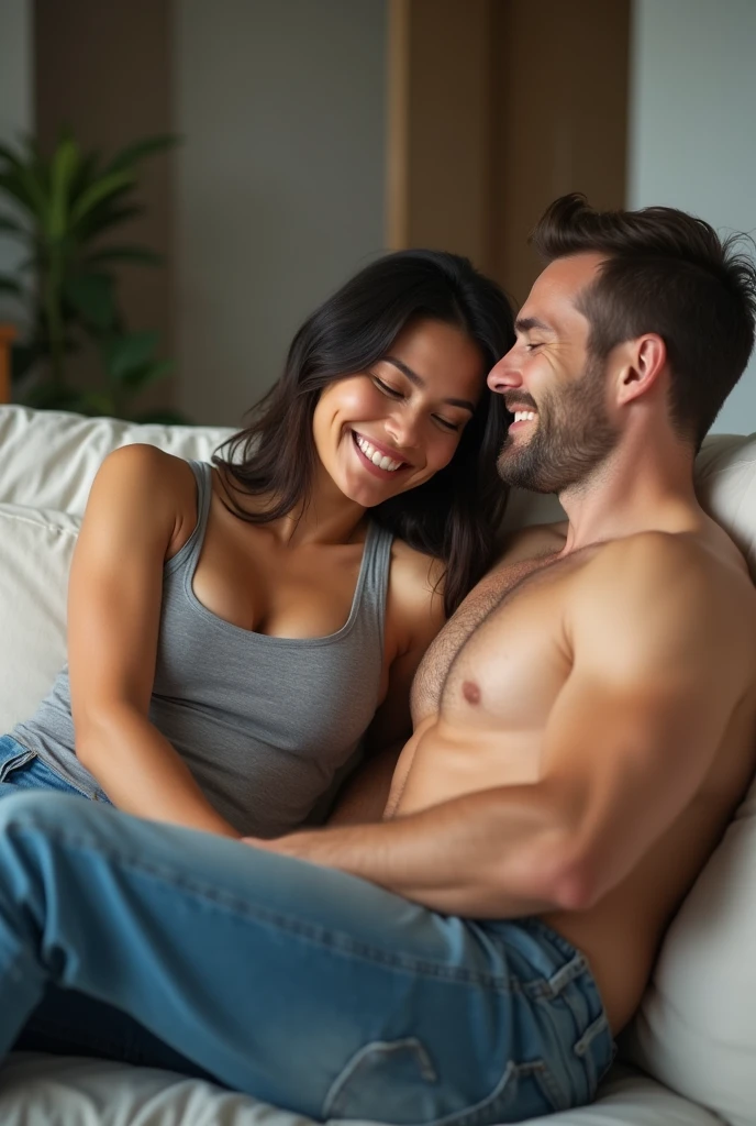 Beautiful athletic 30 year old asian woman wearing tank top and jeans sitting in living room with her shirtless caucasian husband. Smiling. Toned arms. Arms around each other