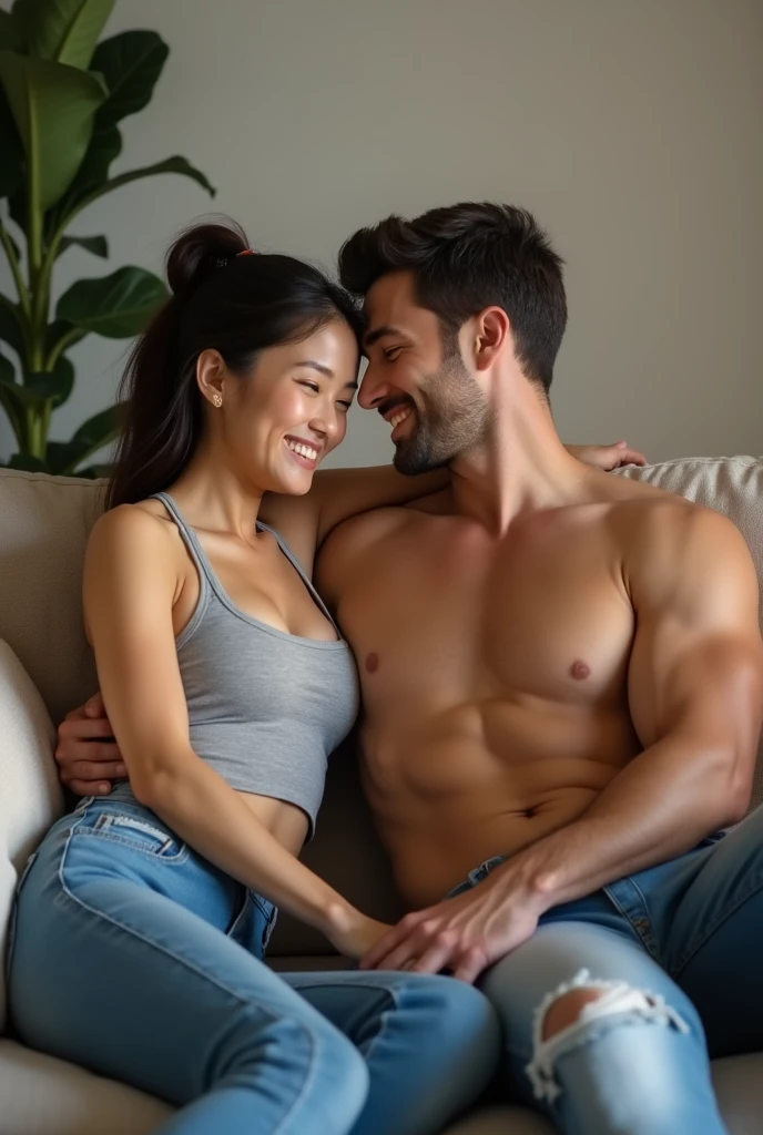 Beautiful athletic 30 year old asian woman wearing tank top and jeans sitting in living room with her shirtless caucasian husband. Smiling. Toned arms. Arms around each other