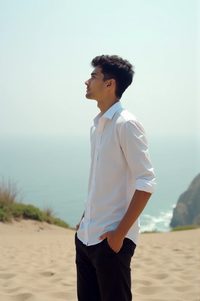 Photo taken by a young man of about 18 years of age ,with white shirt and black pants ,on a beach watching the landscape ,in a general plan
