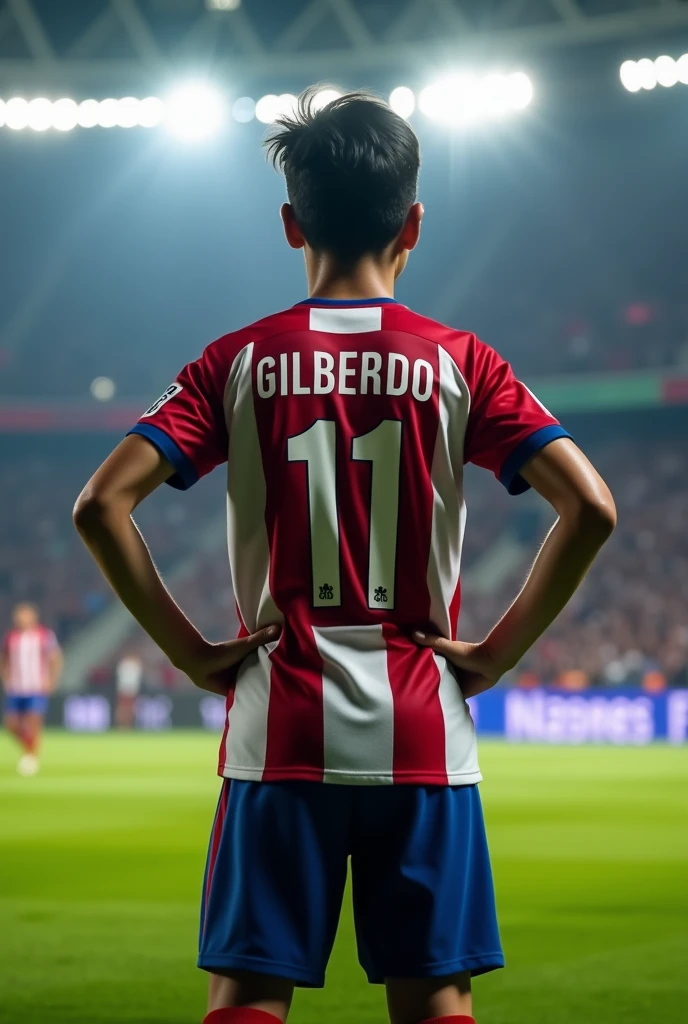High quality photography, of a 19 year old boy playing football, He is standing with his hands on his waist about to kick a free kick with his back turned, with the name Gilberto and the number 11 on his back, He has black hair that is a bit big, with the Atlético Madrid uniform Super realistic