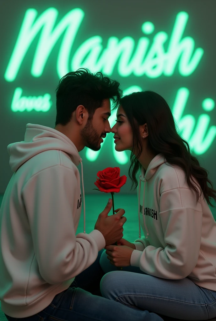 Realistic 24 Year old cute boy White Hoodie with 20 year beautiful girl in a White Hoodie, the girl has a red rose flower in her hand and is sitting on down floor, written "Manish" in the boy hoodie and "Mahi" in girl's hoodie, and Manish love Mahi is written on the green light glow wall text behind.