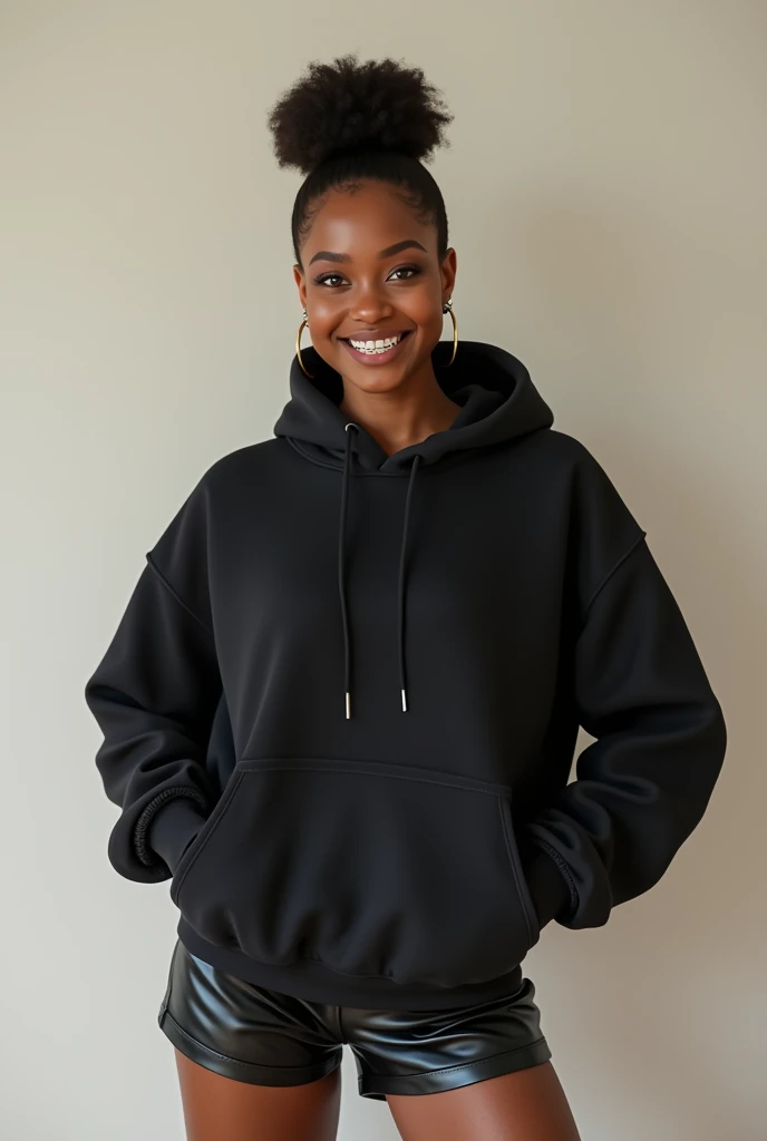 black woman hair in a bun, black leather short shorts, black hoodie smiling braces on teeth
