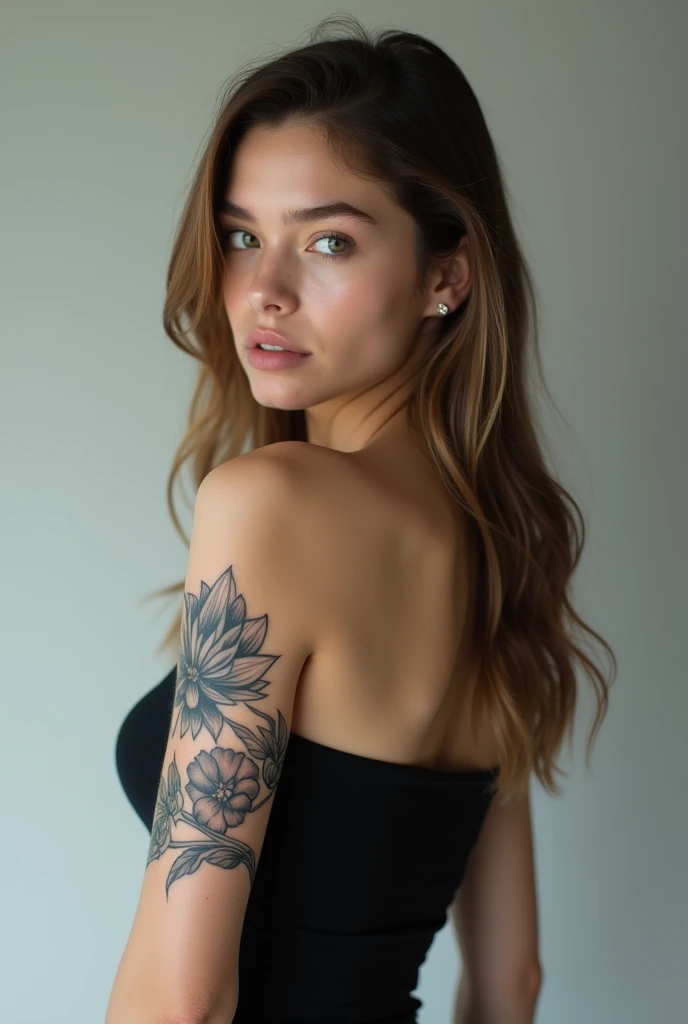 A woman with a medium complexion, likely in her late s to mid-twenties, stands with her back to the camera. Her long, light brown hair cascades down her back, styled straight and loose with a center parting. Her black, strapless top reveals her back and shoulders, and appears to be made of a stretchy material like spandex or a spandex blend, fitting her body closely.
On her right upper arm, a black ink tattoo of a flower with a detailed design covers a significant portion of her skin. The tattoo is intricately designed, with delicate petals and intricate details that catch the light.
The subject's posture is straight, with her arms relaxed at her sides. Her head is turned to look over her right shoulder, her eyes looking directly at the camera with a hint of intensity. Her expression is otherwise neutral, with a subtle, soft quality to her features.
The background is a light grey color with a soft gradient, giving the image a sense of depth and dimensionality. The lighting is soft and diffused, coming from a source in front of the subject, and illuminates her face and upper body evenly. There are no harsh shadows or distractions, keeping the focus squarely on the subject.
The image is high-resolution, with good detail and clarity. The subject's features, tattoos, and clothing are all clearly visible, with a level of texture and dimension that draws the viewer in.
Image Specifications:
Resolution: High-resolution
File format: JPEG or similar
Dimensions: 3000 x 2000 pixels or similar
Color depth: 24-bit or similar
File size: 5-10 MB or similar